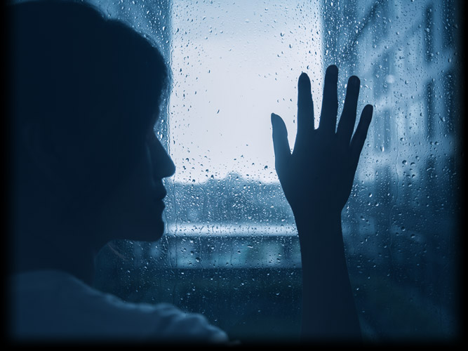 Depressed Woman Looking Out a Window